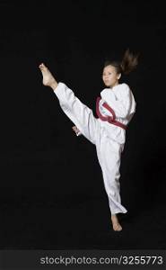 Young woman performing round kick