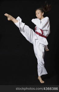 Young woman performing round kick