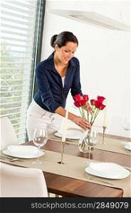 Young woman placing flowers dinner table romantic