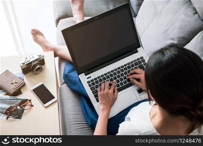 Young woman planning vacation trip and searching information or booking hotel on a laptop