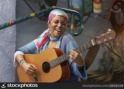Young woman playing a guitar and singing