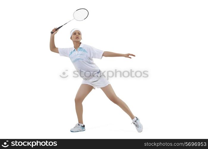 Young woman playing badminton isolated over white background