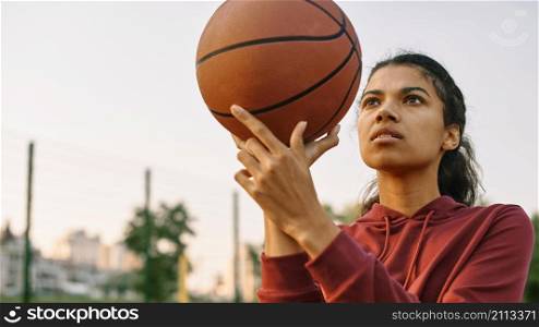 young woman playing basketball outside