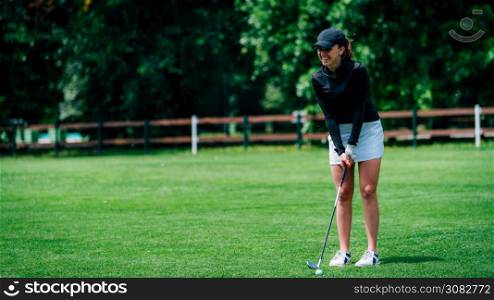 Young woman playing golf on a golf course