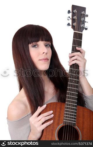 young woman playing guitar at home