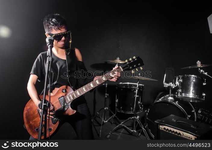 Young woman playing guitar during the concert