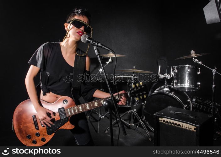 Young woman playing guitar during the concert