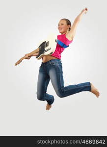 young woman playing on electro guitar and jumping