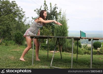 Young woman playing table tennis in nature