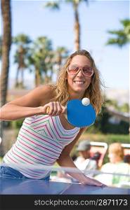 Young woman playing table tennis portrait