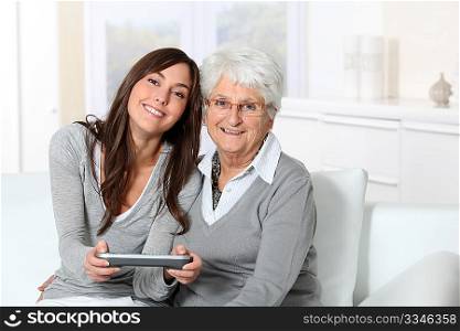 Young woman playing video game with grandmother