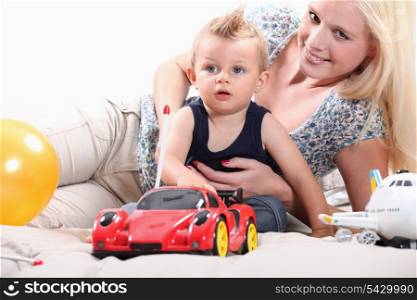 Young woman playing with a little boy and his toys