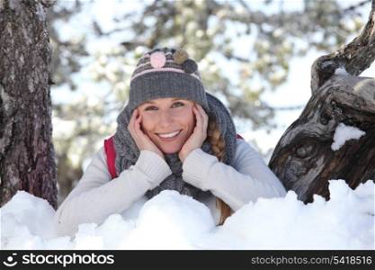 young woman playing with the snow in the park