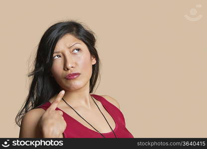 Young woman pointing over colored background