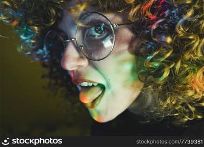 Young woman portrait illuminated by psychedelic lights