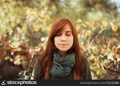 Young woman portrait with closed eyes in the forest