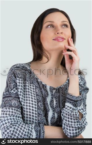 Young woman posing against white background. Beautiful young cheerful lady