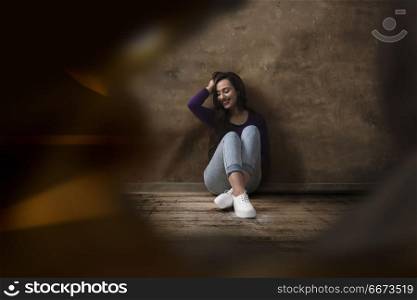 Young woman posing in front of a grunge textured concrete wall