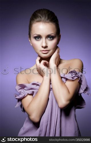 young woman posing in purple dress, studio shot