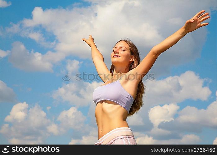 Young woman posing in sky with hands open