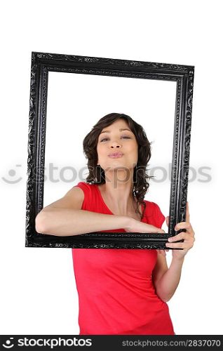 Young woman posing inside a picture frame