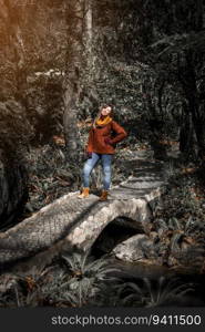 Young woman posing on a stone bridge on the middle of the forest