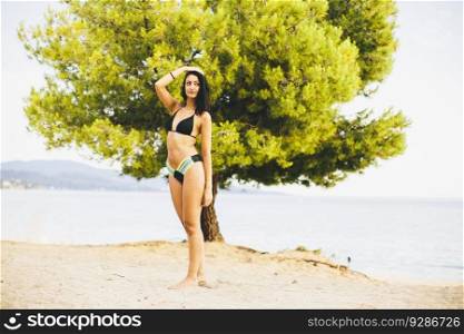 Young woman posing on the beach in a bikini