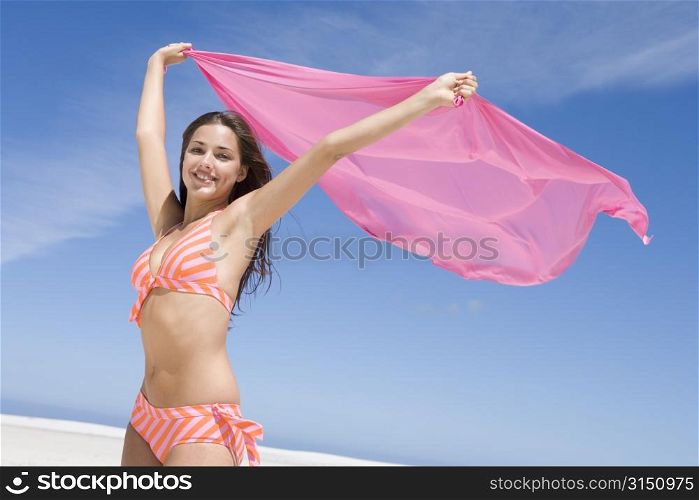 Young woman posing with a scarf on a beach