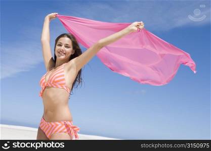 Young woman posing with a scarf on a beach