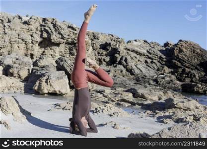 Young woman practice balance asanas on Summer yoga session on a beautiful beach at Formentera, Baleares, Spain