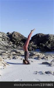 Young woman practice balance asanas on Summer yoga session on a beautiful beach at Formentera, Baleares, Spain