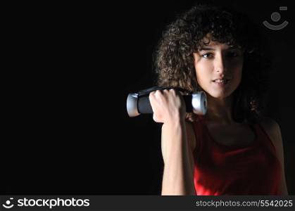 young woman practicing fitness and working out in a gym with dumbbell, weight lifting concept.