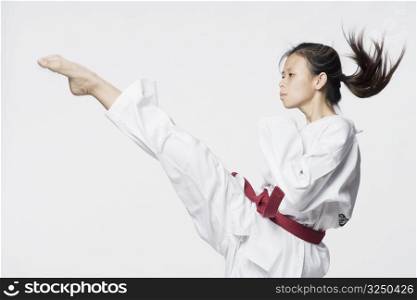 Young woman practicing kicking
