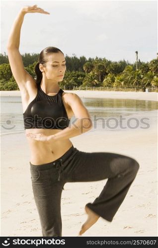 Young woman practicing martial arts on the beach
