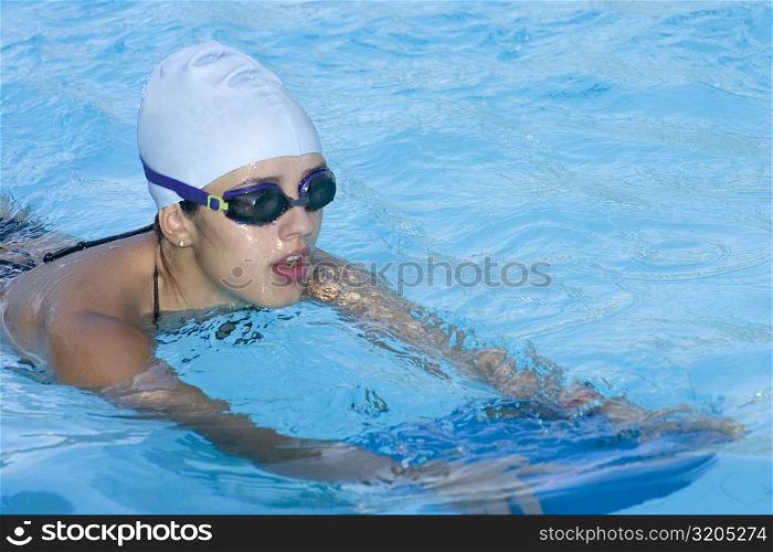 Young woman practicing swimming in a swimming pool