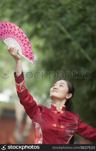 Young Woman Practicing Tai Ji With Traditional Chinese Fan