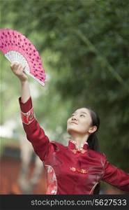 Young Woman Practicing Tai Ji With Traditional Chinese Fan