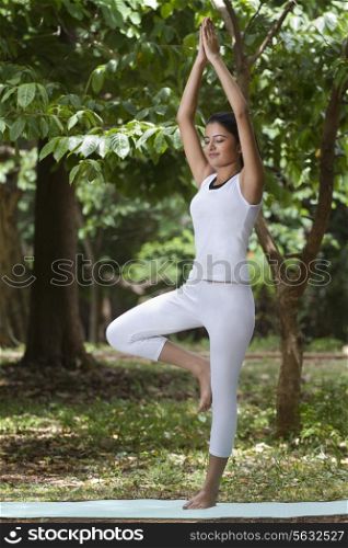 Young woman practicing yoga in a park