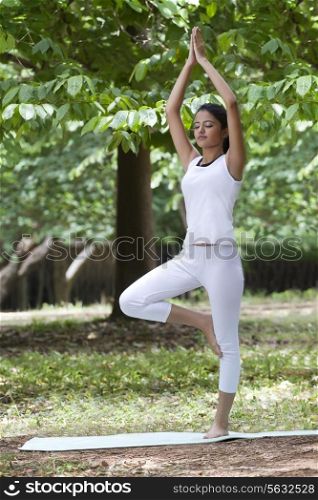 Young woman practicing yoga in a park