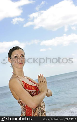 Young woman practicing yoga on the beach