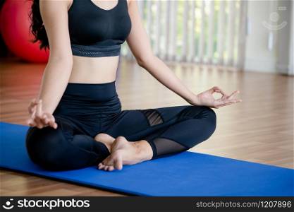 Young woman practicing yoga position in an indoor gym studio. Healthy and wellness lifestyle concept.. Young woman practice yoga in an gym studio.