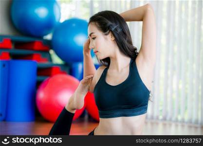 Young woman practicing yoga position in an indoor gym studio. Healthy and wellness lifestyle concept.. Young woman practice yoga in an gym studio.