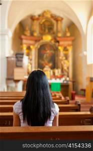 young woman praying in a church. peace and prayer