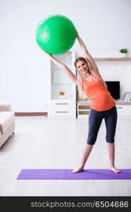 Young woman preparing for birth exercising at home