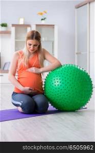Young woman preparing for birth exercising at home