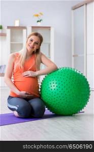 Young woman preparing for birth exercising at home