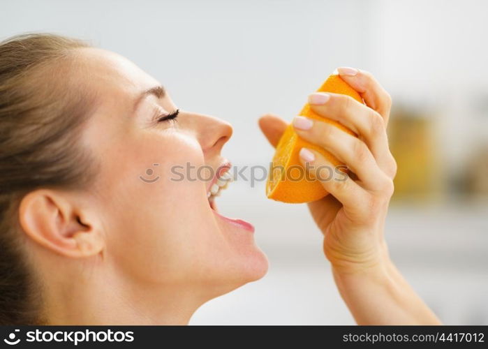 Young woman pressing orange juice in mouth