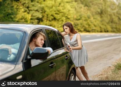Young woman pushing broken car with man on road, breakdown. Crashed automobile or emergency accident with vehicle, trouble with engine on highway. Young woman pushing broken car with man on road
