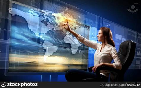 Young woman pushing icon. Young woman in armchair pushing icon on media screen