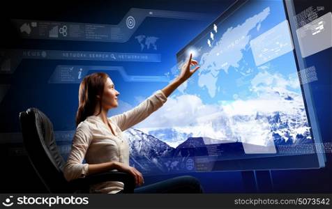 Young woman pushing icon. Young woman in armchair pushing icon on media screen